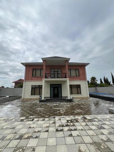 a large house with a red and white at Red Brick House in Şürük