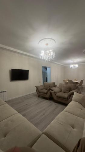 a living room with couches and a chandelier at Red Brick House in Şürük