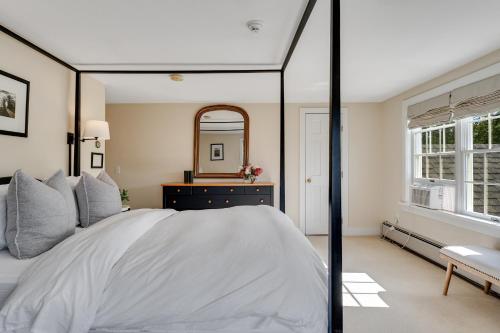 a bedroom with a large white bed and a mirror at Red Clover Inn in Mendon