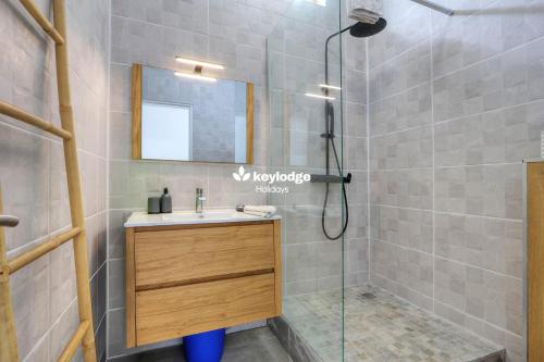 a bathroom with a shower with a sink and a mirror at Mosala 4 - T3 pieds dans l'eau à Saint-Leu in Saint-Leu