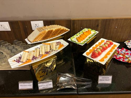 a buffet with different types of food on display at Hotel Cardinal Express Oxmo Delhi Airport in New Delhi