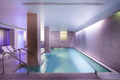a swimming pool in a large room with at Palazzo Montemartini Rome, A Radisson Collection Hotel in Rome
