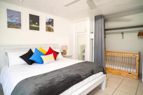 a bedroom with a large white bed with colorful pillows at Antigua Bay Villa in Bats Cave