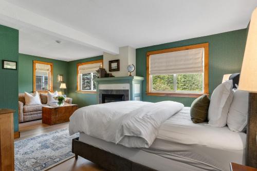 a bedroom with green walls and a bed and a fireplace at Red Clover Inn in Mendon