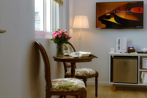a table with two chairs and a vase of flowers at Nguyên Homestay in Can Tho