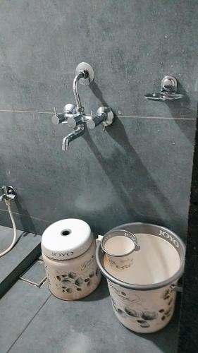 a bathroom with a toilet and a sink and a faucet at Cherry on the top Homestay With AC bedroom in Kolhapur