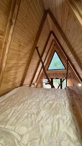 a bed in a wooden room with a window at Old farm 1 in Ijevan