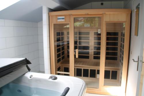 a wooden cabinet with glass doors in a kitchen at La petite auberge de niaux in Niaux