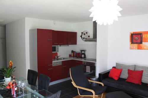 a kitchen and a living room with red cabinets at Family Apartment Sonja Terrace & mountain view in Rauris