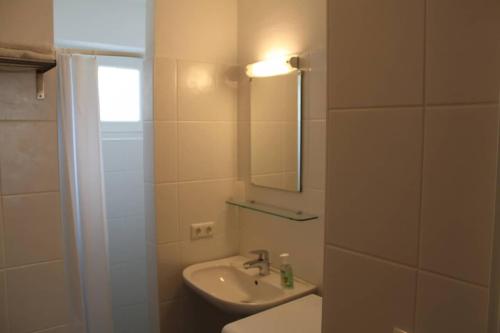 a bathroom with a sink and a toilet and a mirror at Family Apartment Sonja Terrace & mountain view in Rauris