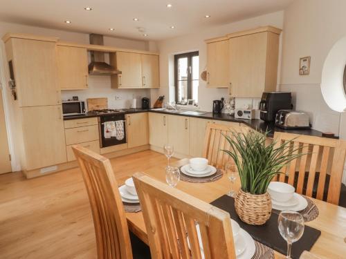 a kitchen and dining room with a table and chairs at Awel y Môr in Burry Port