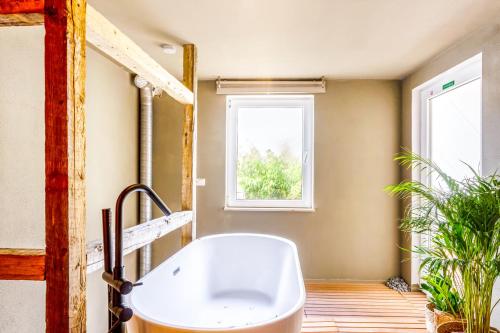 a bathroom with a bath tub and a window at Wielerhuuske in Spaubeek