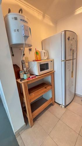 a microwave on a table next to a refrigerator at La Cañada in Rafaela