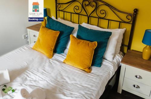 a bed with yellow and blue pillows on it at Spacious 5 Family Rooms House By Shropshire Escapes Short Lets & Serviced Accommodation Shrewsbury With Free WiFi in Shrewsbury