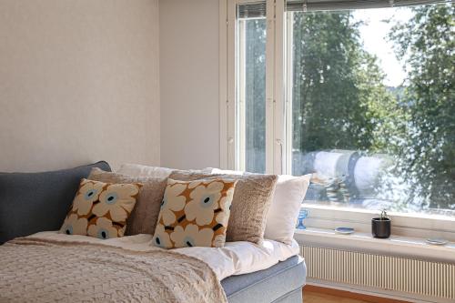 a couch in a living room with a window at Arctic Sauna Suite Rovaniemi in Rovaniemi