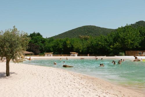 a group of people swimming in the water on a beach at Slow Village Anduze - Cévennes in Corbés