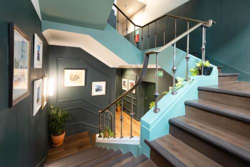 a staircase with blue walls and wooden floors at Charles Hope Boutique Hometel in Cape Town