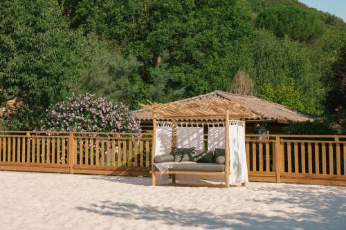a gazebo with a couch in front of a fence at Slow Village Anduze - Cévennes in Corbés