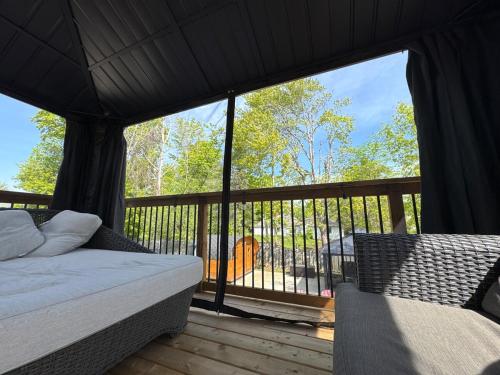 Un dormitorio con una cama y un balcón con vistas. en Hot Tub BANYA Sauna True Cottage experience, en Innisfil