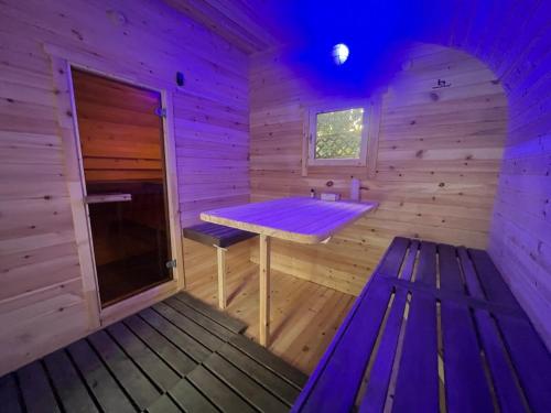 una sauna de madera con una mesa de madera y un banco en Hot Tub BANYA Sauna True Cottage experience, en Innisfil