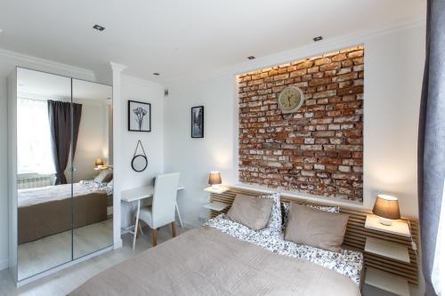 a bedroom with a brick wall and a large bed at Apartamenty Sienkiewicza - bezpłatny parking, centrum, park, fv in Kielce