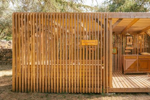 a wooden fence with a gate on a wooden deck at Slow Village Anduze - Cévennes in Corbés