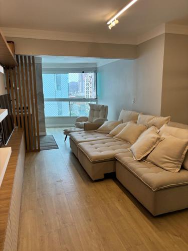 a living room with a large couch in a room at Apartamento espaçoso Praia Brava in Itajaí