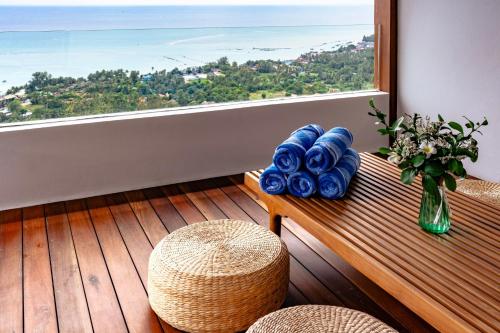 a room with a window and a table with a vase of flowers at Anzhu Seamate Villa Samui in Amphoe Koh Samui