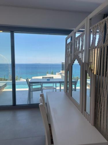 a balcony with a table and a view of the ocean at Zante Fiore Suites in Xirokástellon
