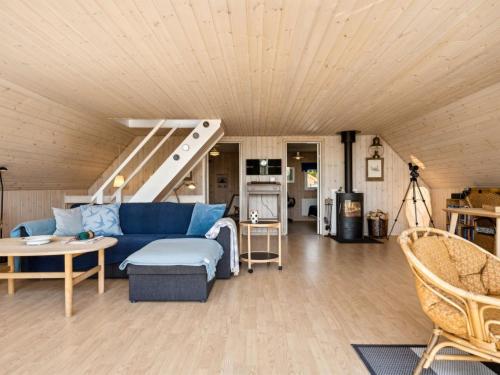 a living room with a blue couch and a table at Holiday Home Eikka - 100m from the sea by Interhome in Knebel
