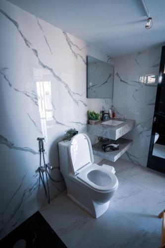 a white bathroom with a toilet and a sink at Safari Desert Camp in Shāhiq