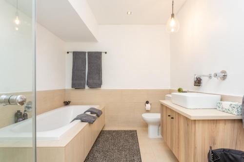 ein Badezimmer mit Badewanne, Waschbecken und Toilette in der Unterkunft Edgy On Bree in Kapstadt