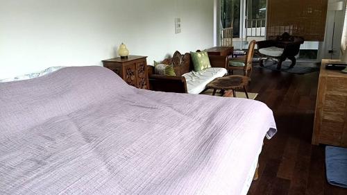 a bedroom with a large bed and a living room at Sanae in Sathani Khao Tao