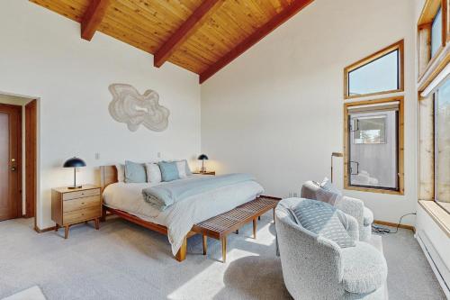 a bedroom with a bed and two chairs and a window at Timber & Tide in Sea Ranch