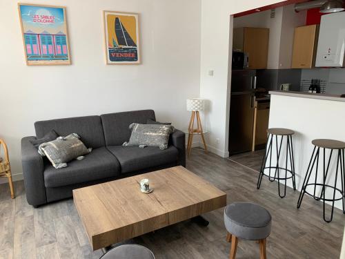 a living room with a couch and a coffee table at Les Sables d'Olonne, Les Présidents, charmant appartement lumineux, plage 150 m. in La Rudelière