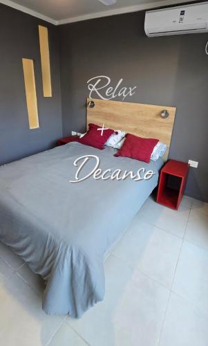 a bedroom with a bed with a sign that says relax demand at Departamento centro in Paraná
