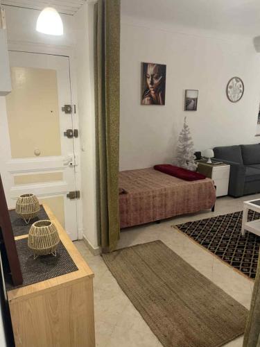 a bedroom with a bed and a living room with a couch at 3 minutes walking to monaco & the beach in Beausoleil