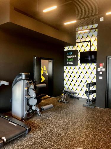a fitness room with a gym with machines and a sign at Midtown Towers TLV in Tel Aviv