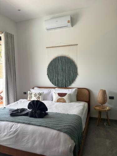 a bedroom with a bed with a black hat on it at Villa Selva, Lamai in Amphoe Koh Samui