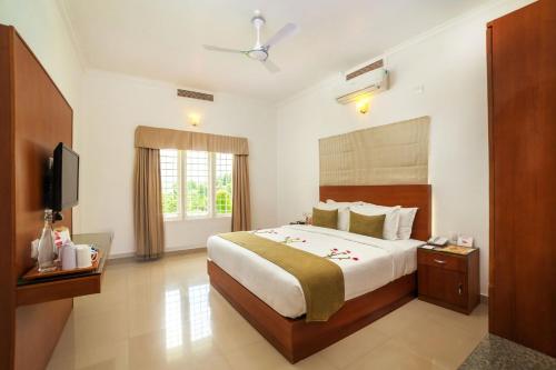 a hotel room with a bed and a television at The Fog Munnar (Resort & Spa) in Munnar