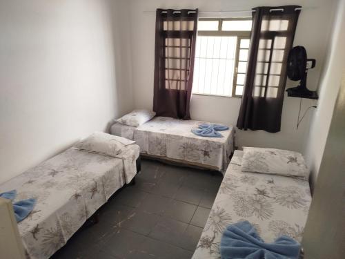 a room with three beds and a window at Casa perto de Aparecida - Cantinho da Fé in Potim