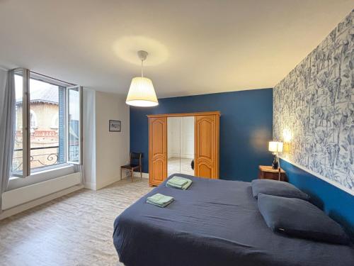 a blue bedroom with a bed and a large window at Hypercentral Champagne Nest in Épernay