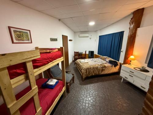 a room with two bunk beds and a desk at Fario Fishing Lodge in Villa El Chocón