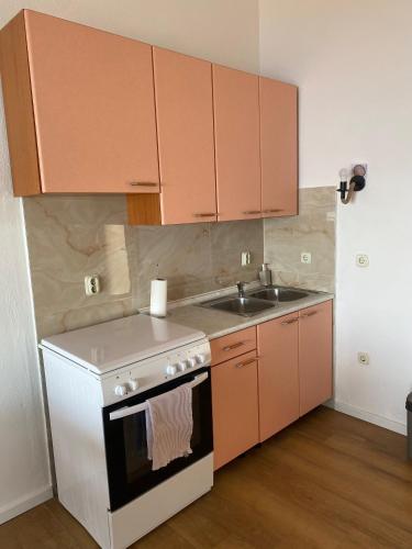 a small kitchen with a stove and a sink at Villa Roing R in Stanići