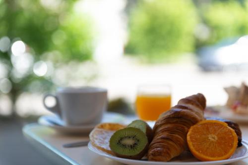 サン・プリエストにあるEastLodge Lyon Est Eurexpoのテーブルの上にオレンジとキウイが乗った料理の皿