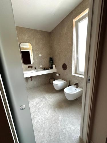 a bathroom with a sink and a toilet and a mirror at Villa Margherita in Padova