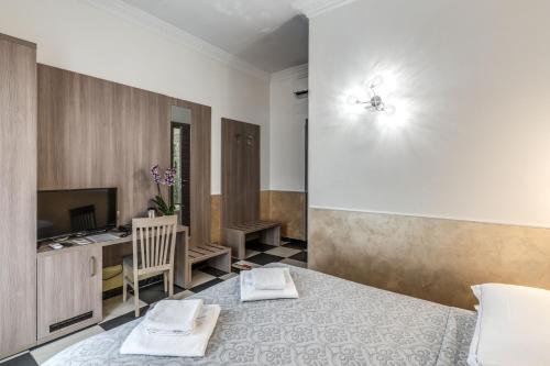 a bedroom with a bed and a desk and a tv at Hotel Centro Cavour Roma in Rome