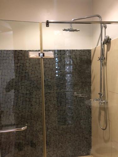 a shower with a glass door in a bathroom at Enkombe Place in Kampala