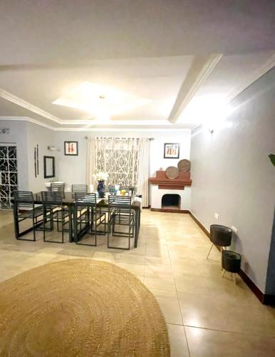 a dining room with a table and chairs and a fireplace at Saly and Jay Homes karatu in Nkunjila