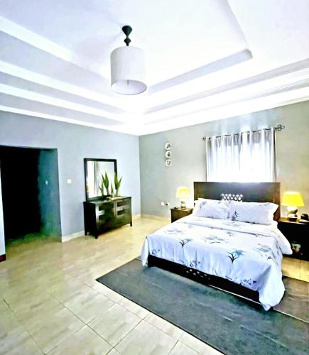 a bedroom with a large bed and a ceiling at Saly and Jay Homes karatu in Nkunjila